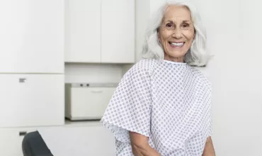 Elderly woman patient smiling in doctors room